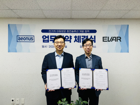 이훈 ㈜에바 대표와 허은 이온어스㈜ 대표가 신형 전기차 이동방문차량 앞에서 업무협약서을 체결했다.   [이온어스㈜ 제공]